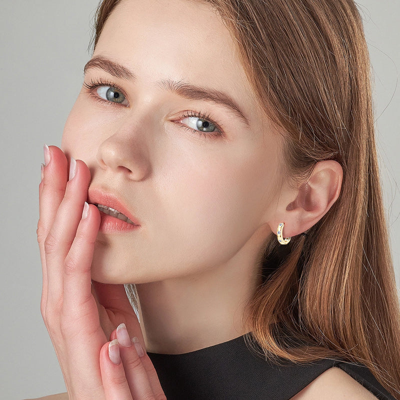 Side profile view of moissanite huggie earrings in sterling silver