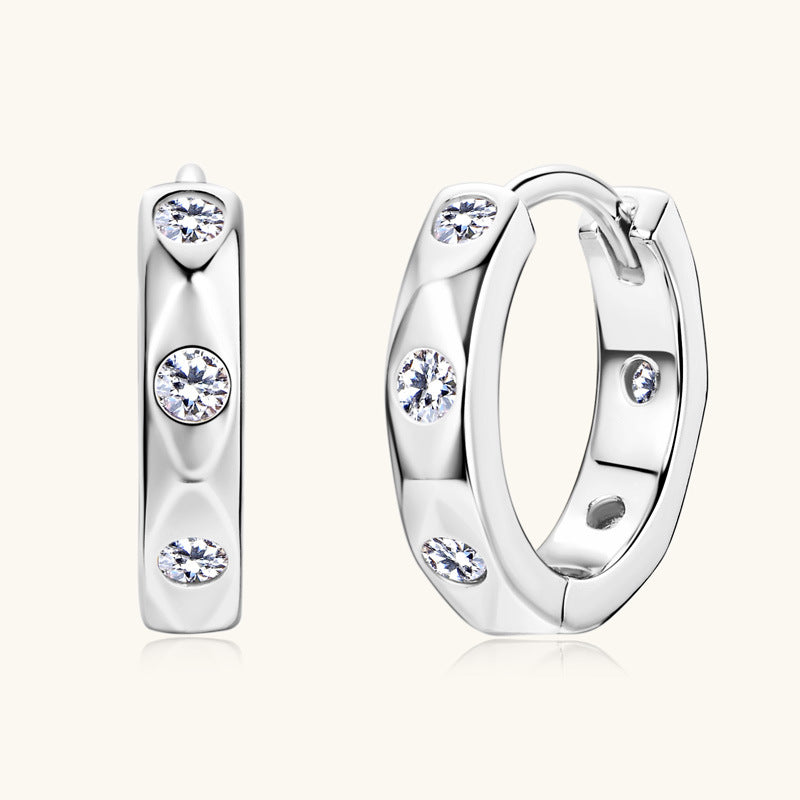 Front facing view of sterling silver huggie earrings with moissanite