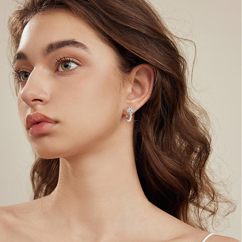 Texture detail of sterling silver huggie earrings showing smooth finish and moissanite sparkle