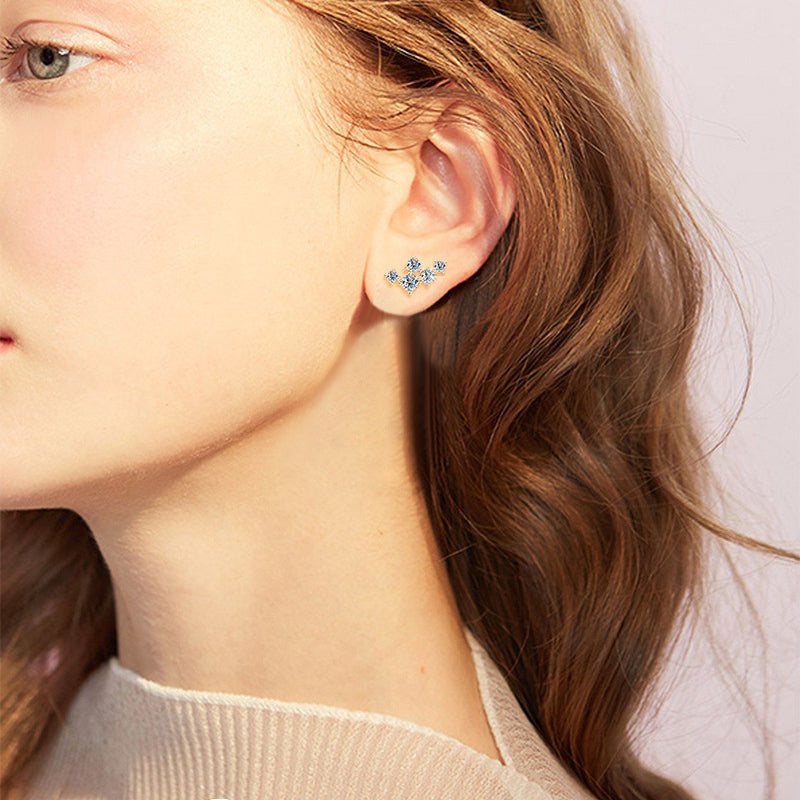 Flat back design of 14K gold star moissanite studs demonstrating comfortable fit against ear for extended wear