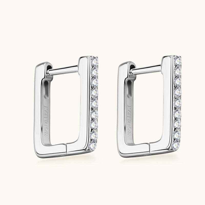 Close up of luckinging silver stud earrings with moissanite stones