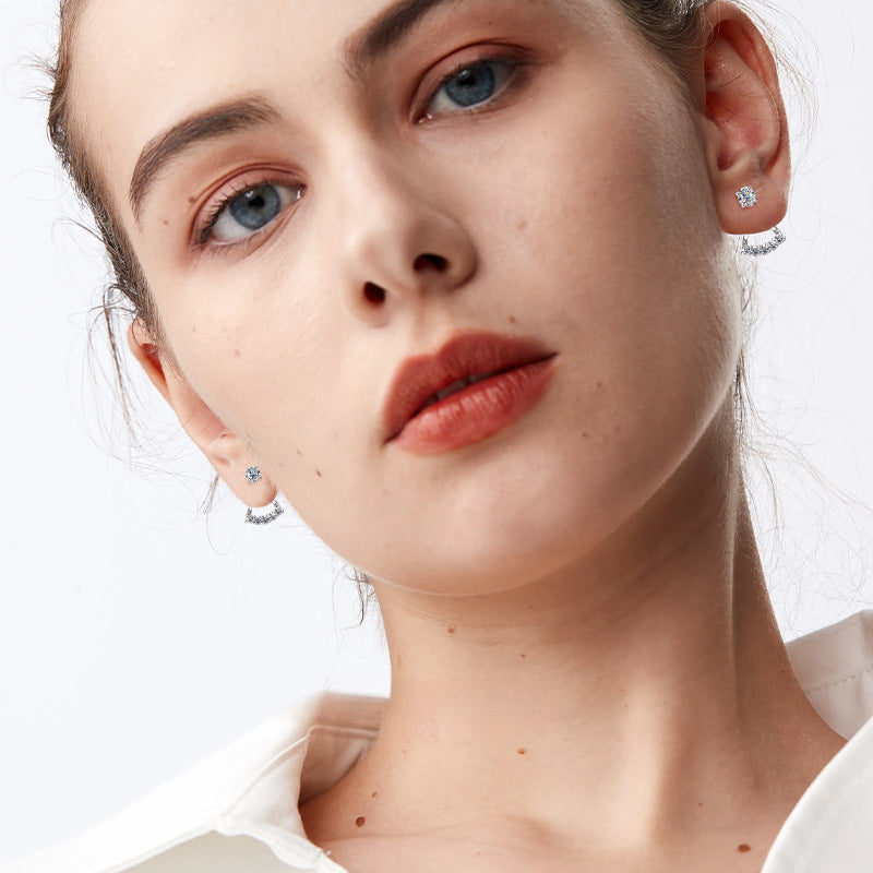 Focus on moissanite stones and silver frame of butterfly earrings
