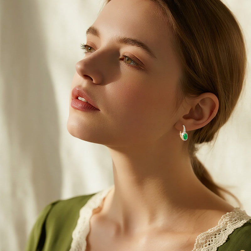 Close-up of oval synthetic emerald stone in huggie setting