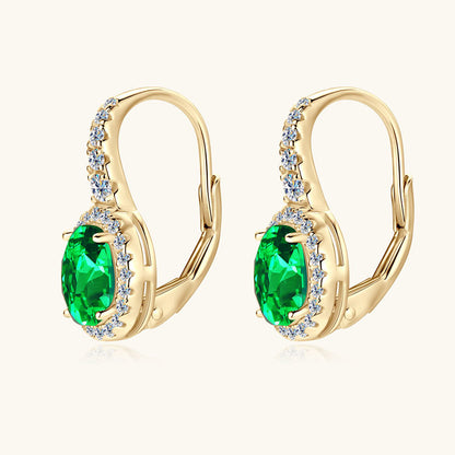 Sterling silver emerald huggie earrings front view showing brilliant oval cut green stones