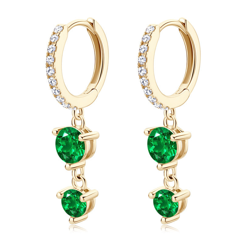 Pair of emerald dangle earrings on white background