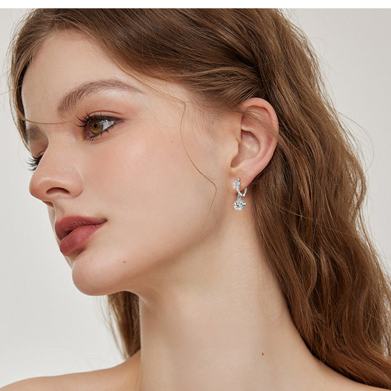 Close-up of floral cluster design on silver dangle earring
