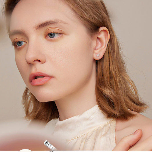 Side view of delicate flower stud earrings