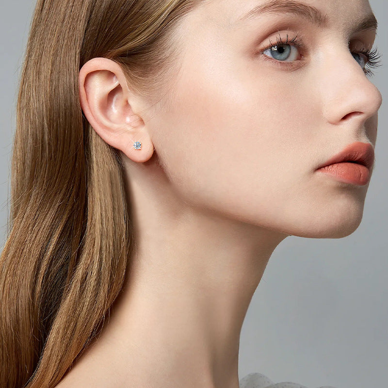 Side view of gold flower stud earring on model ear