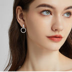 Side profile of gold hoop dangle earrings showing drop design