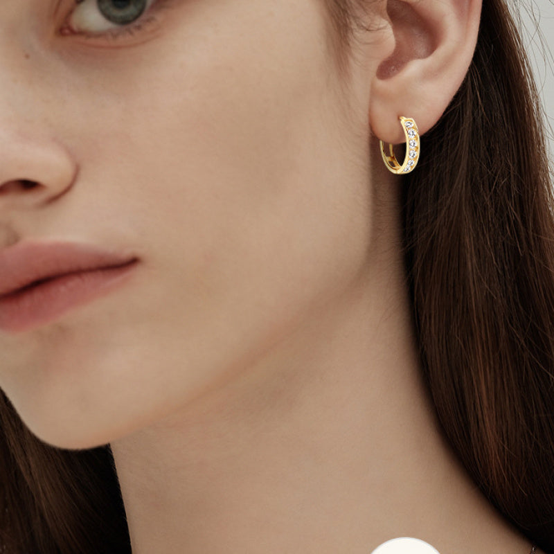 Detail of six moissanite stones set in a gold hoop design