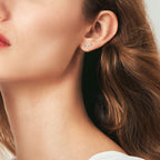Close-up detail of diamond-cut moissanite stones on gold star earrings