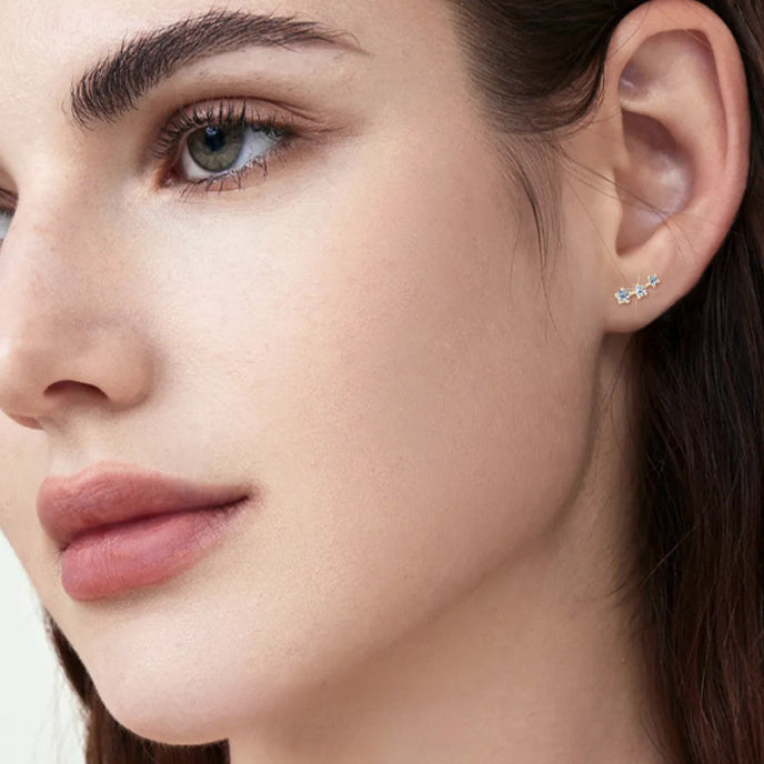 Side angle shot of flat back gold star stud earrings