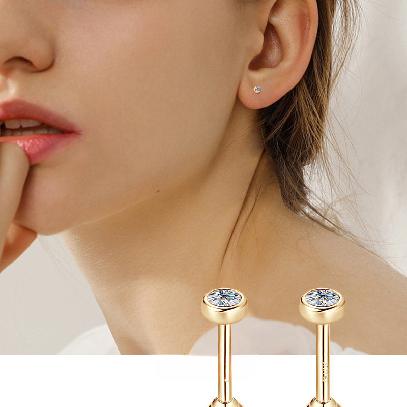 Closeup of gold earring with teardrop gemstone and flat back post