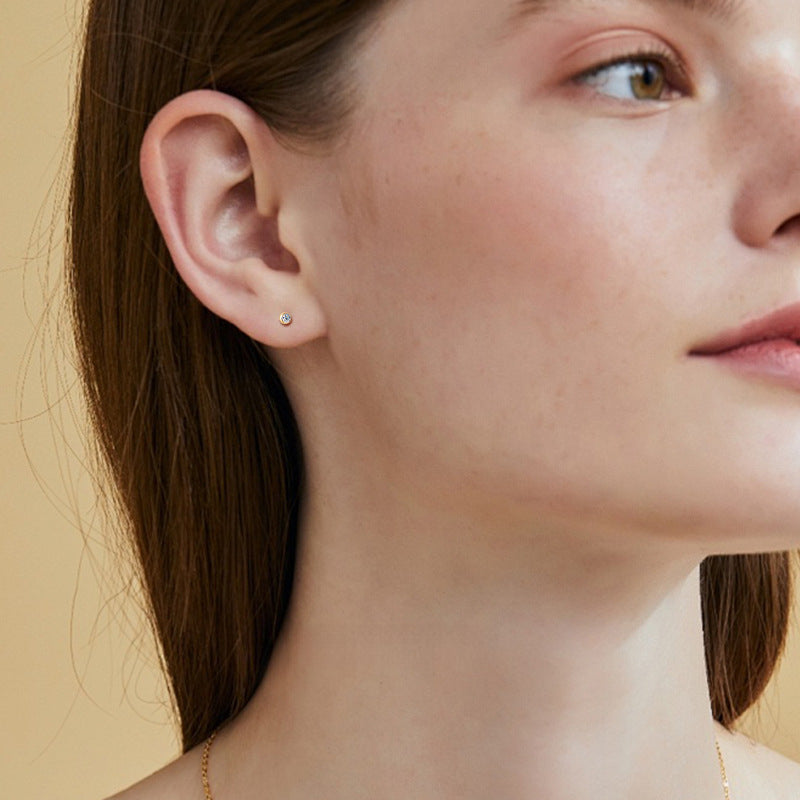 Simple gold stud earring with clear teardrop moissanite center