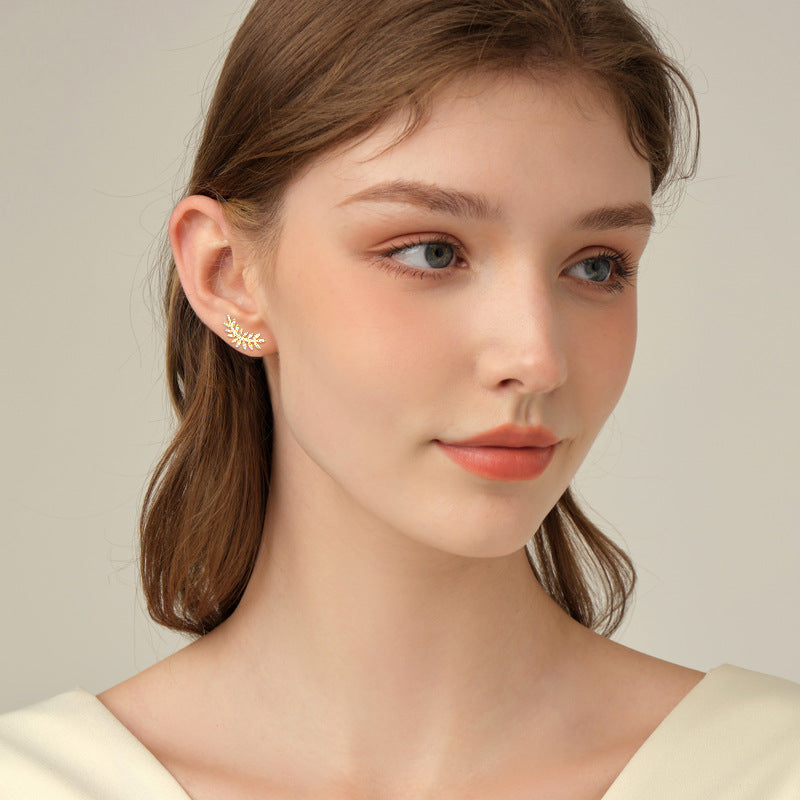 Lifestyle image of leaf moissanite earrings on woman's ear