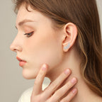Earrings worn on ear showing how they dangle and catch light