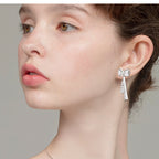 Angle view of Luckinging bow stud earring on model's ear