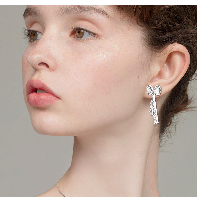 Angle view of Luckinging bow stud earring on model's ear