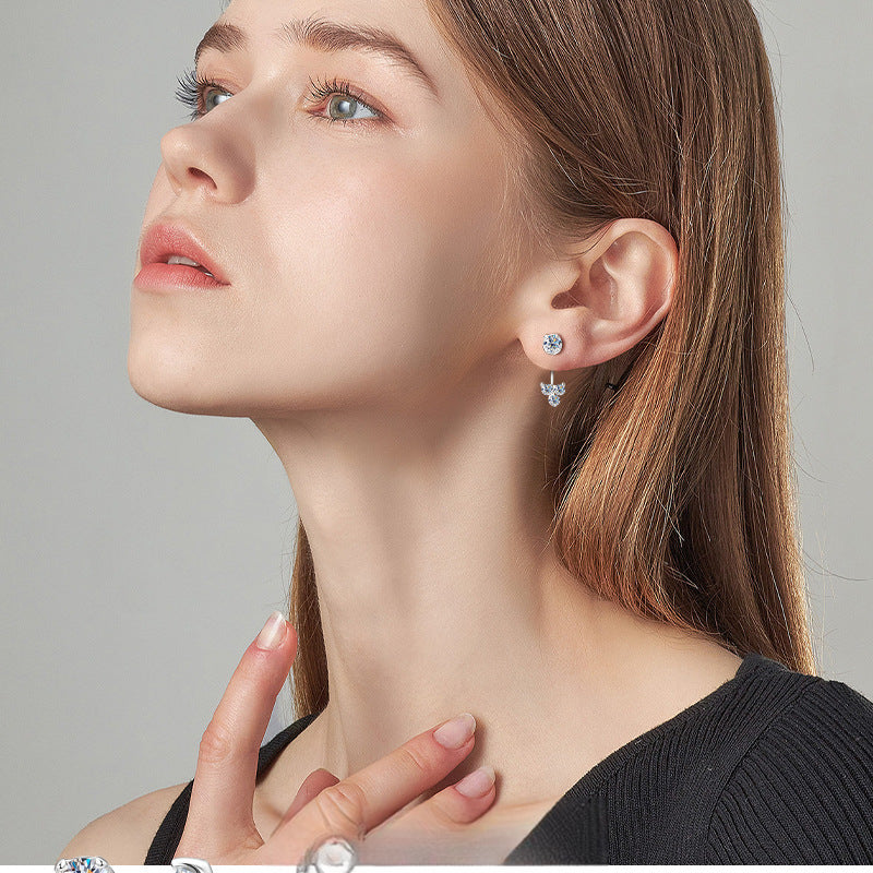 Luckinging moissanite dangle earrings hanging from a model's ear