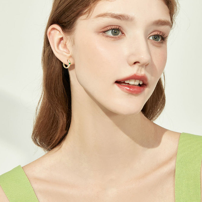Side profile view of the huggie hoop with emerald stone