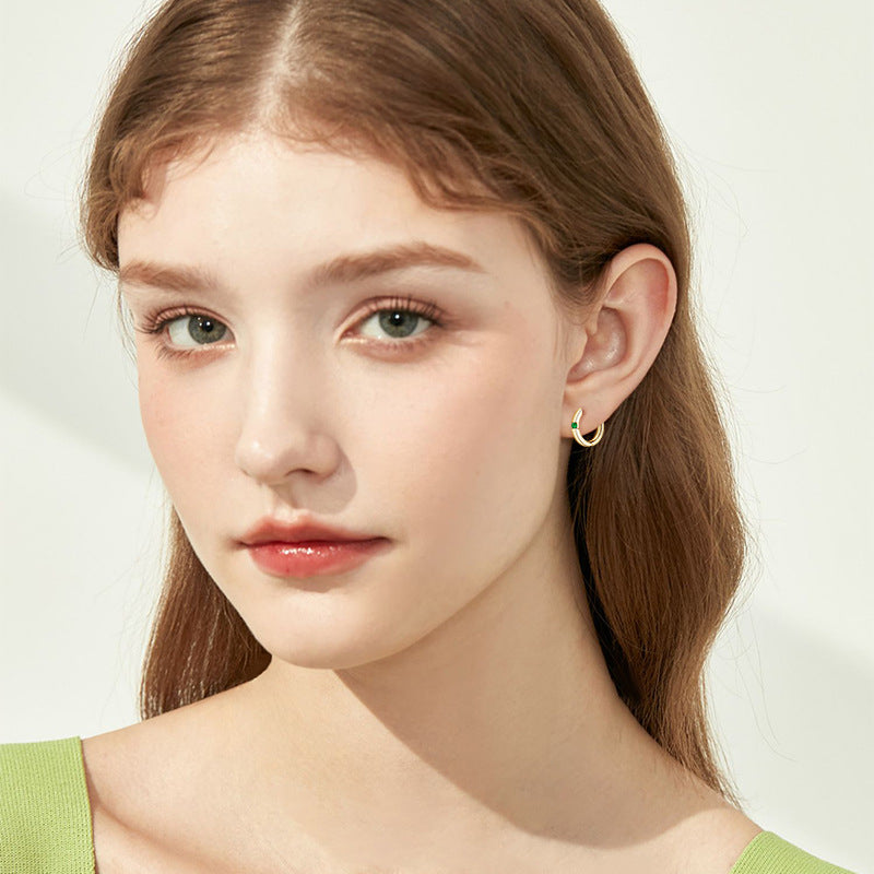 Image showcasing the flat back design of the earring on a model's ear