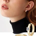 Minimalist huggie gold hoop earring on white background