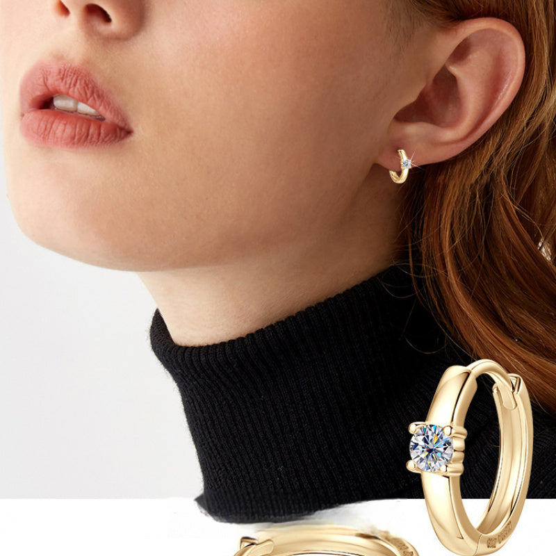 Minimalist huggie gold hoop earring on white background