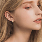 Small gold hoop earring featuring a sparkling stone