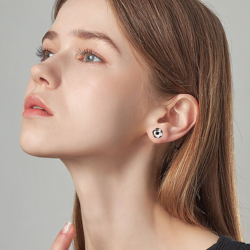 Pair of Luckinging football moissanite stud earrings on model ear