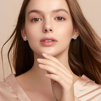 Close detail of silver star earrings with small moissanite stones