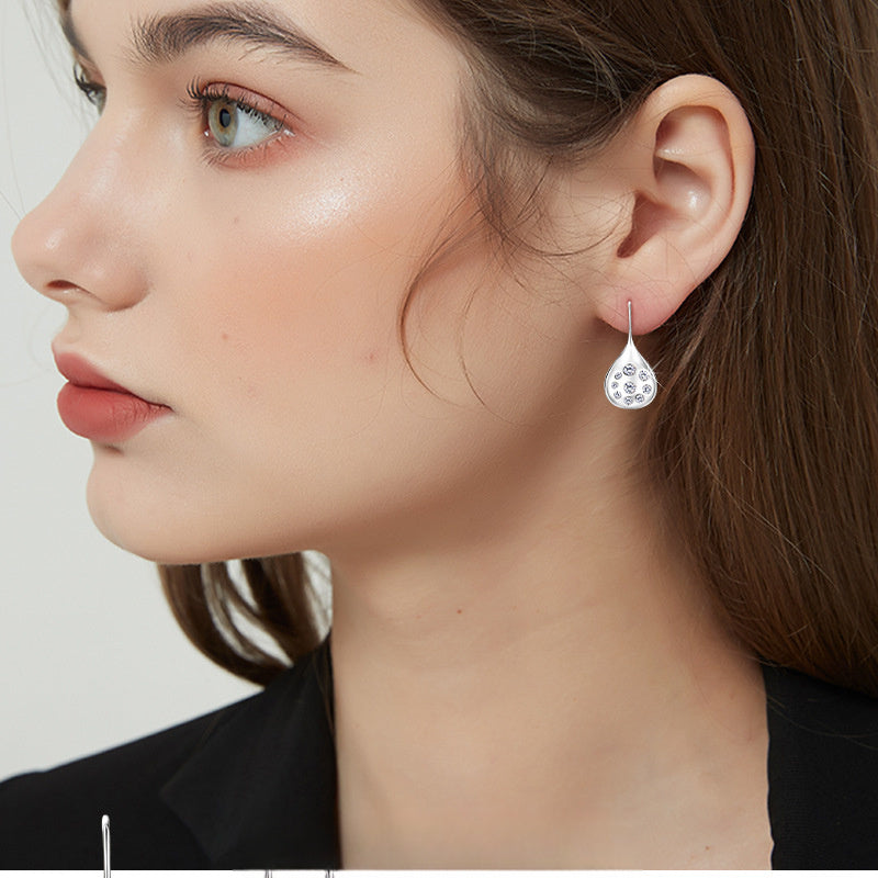 Close-up detail of the moissanite stones set in the teardrop silver pendants