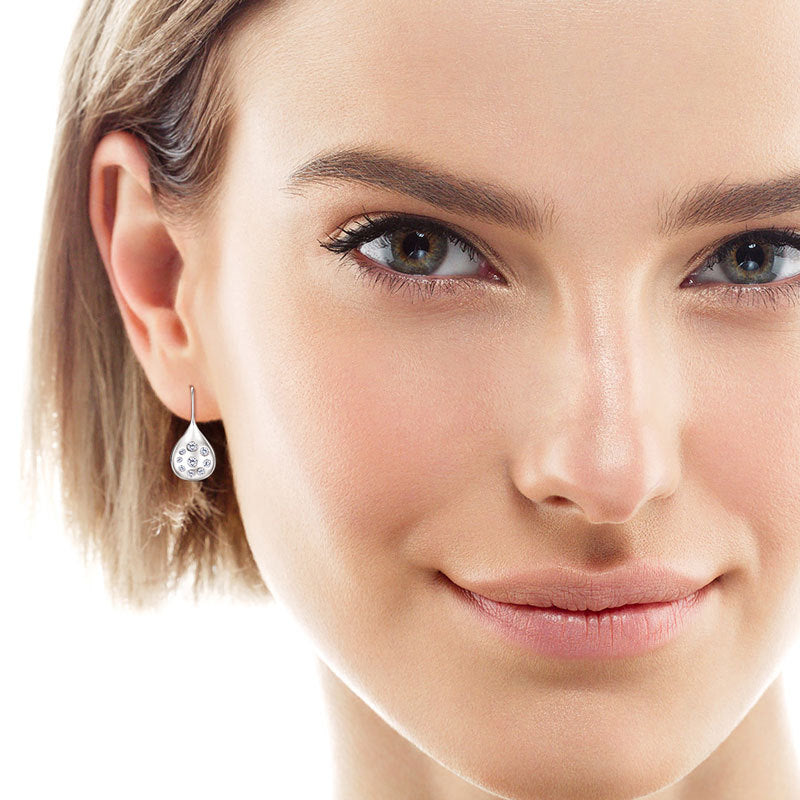 Earrings being tried on the ear to show fit and comfort