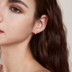 Image of gold dangle earring with moissanite dropped gracefully