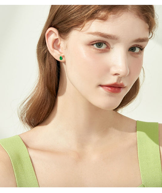 Side view of luxury emerald drop hoop earrings in gold