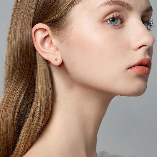 Close up detail of luxury flower stud earrings featuring brilliant moissanite and polished gold finish