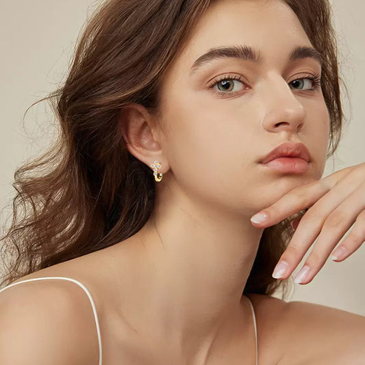 Premium lifestyle image of huggie stud earrings worn in professional elegant setting