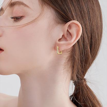 Professional product shot of authentic 14K gold huggie hoop earrings