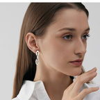 Stacked silver hoop earrings on a model's ear for layering inspiration