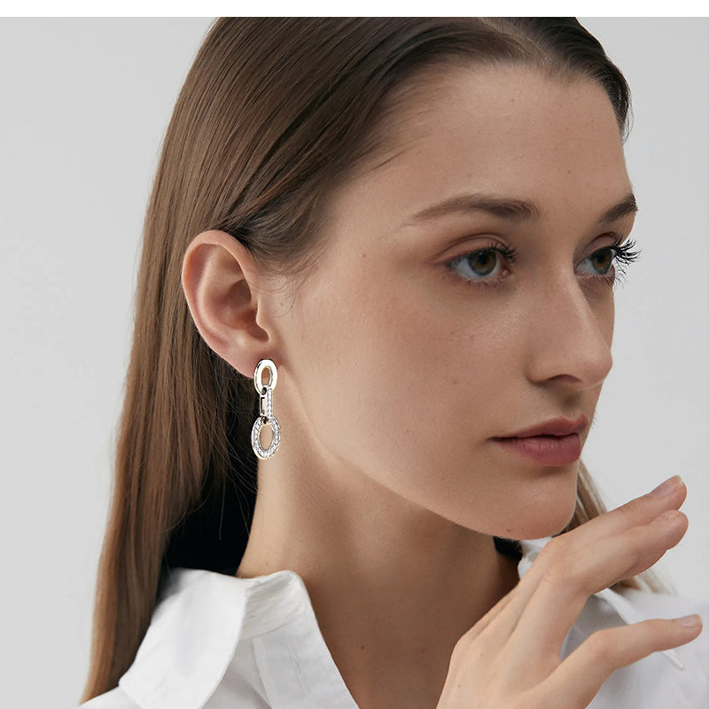 Stacked silver hoop earrings on a model's ear for layering inspiration