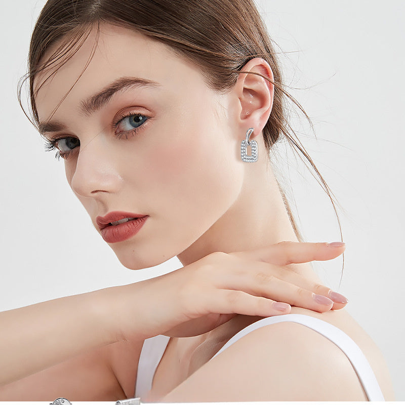 Side view of silver dangle earring with square frame