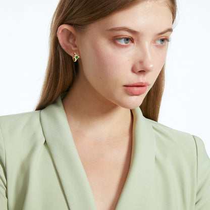 Detailed closeup of emerald star setting in 14K gold huggie earring craftsmanship