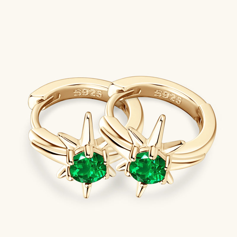 Lifestyle image of the star emerald huggie earrings being worn