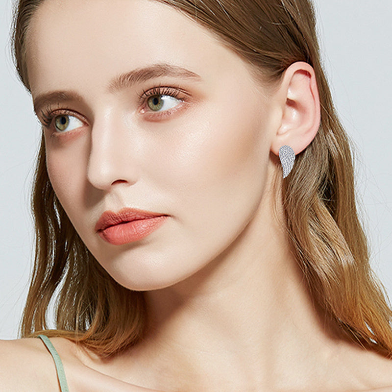 Professional styling showcase of sterling silver moissanite huggie hoops paired with business attire and elegant accessories