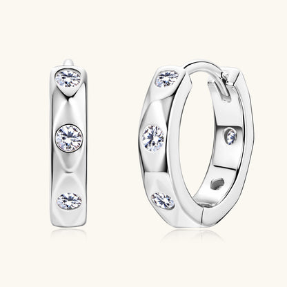 Front facing view of sterling silver huggie earrings with moissanite
